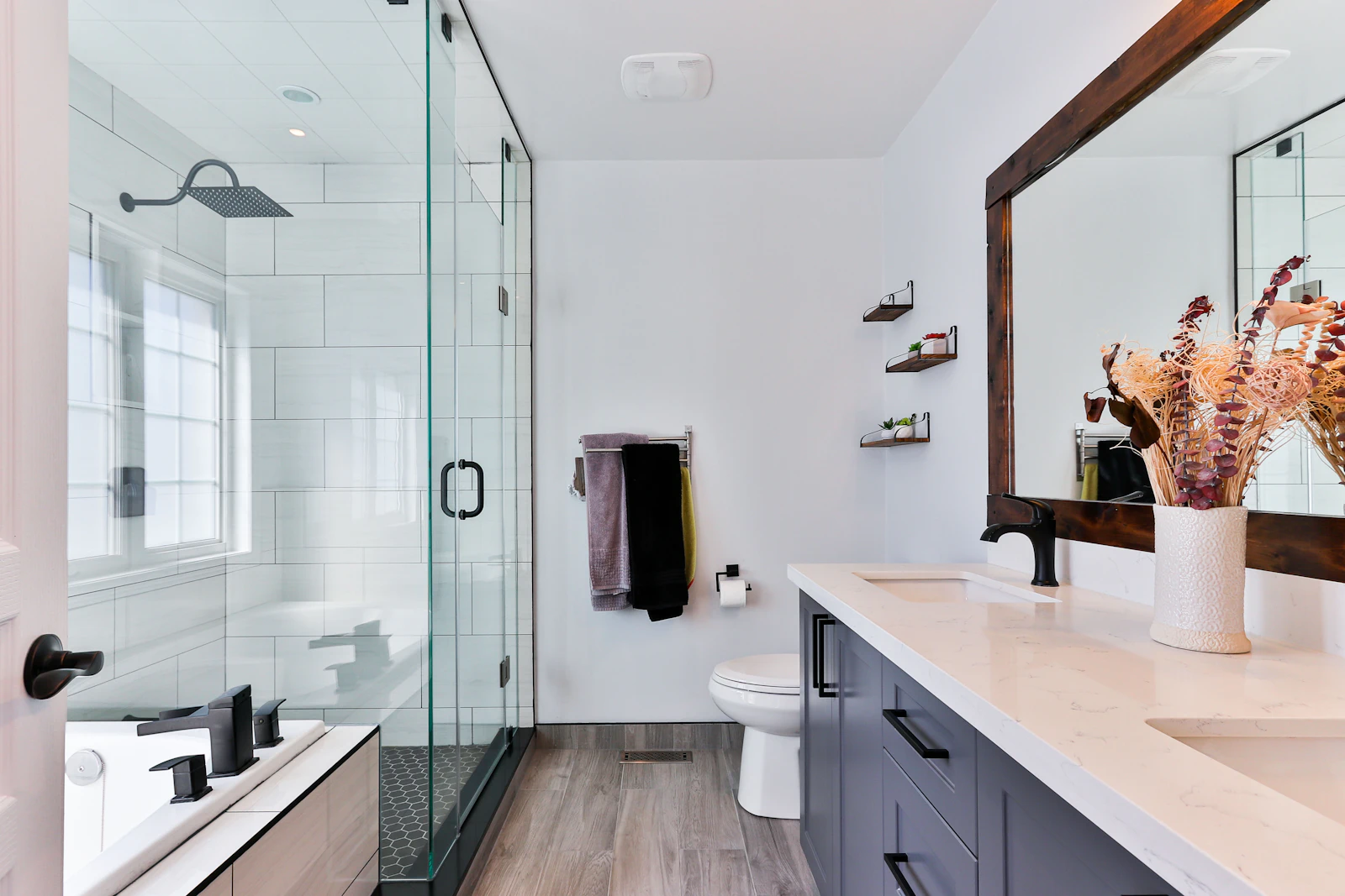 Completed modern bathroom remodel with tile, glass shower, vanity, and new fixtures
